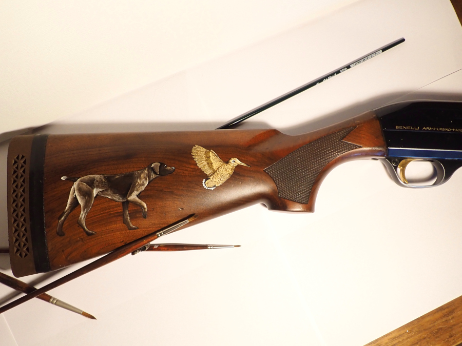 Chien et bécasse en peinture sur crosse de fusil de chasse.